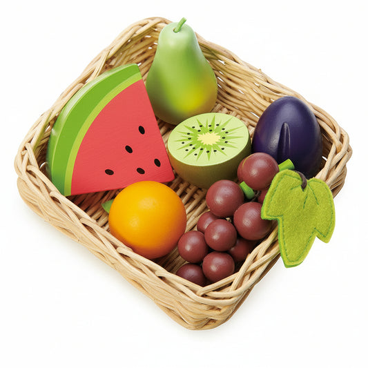 Wicker basket with toy fruits and vegetables on a white background